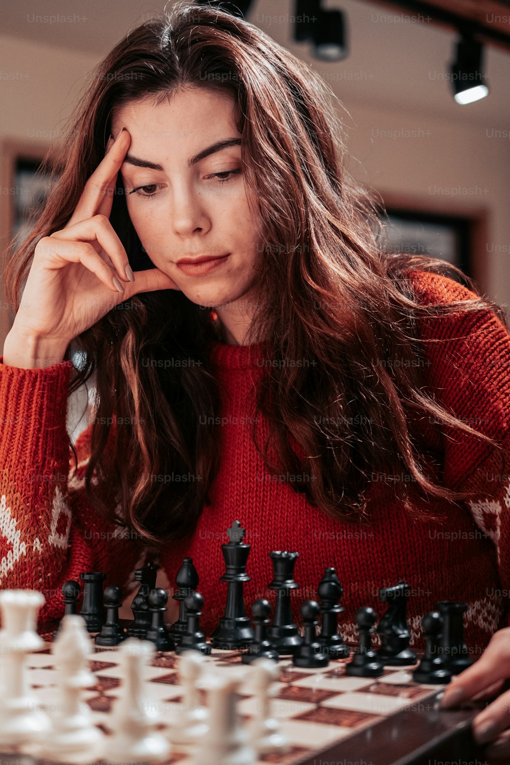 a woman with her hand on her face and a chess board