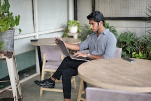 a person sitting at a table using a laptop