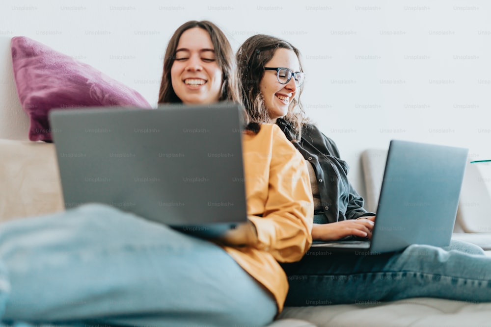 women sitting on a couch with a laptop