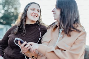 a couple of women looking at a cell phone