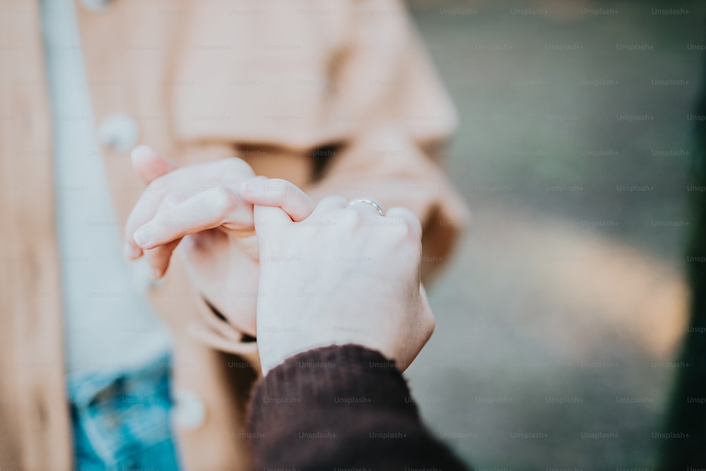 um close-up de uma pessoa segurando as mãos juntas