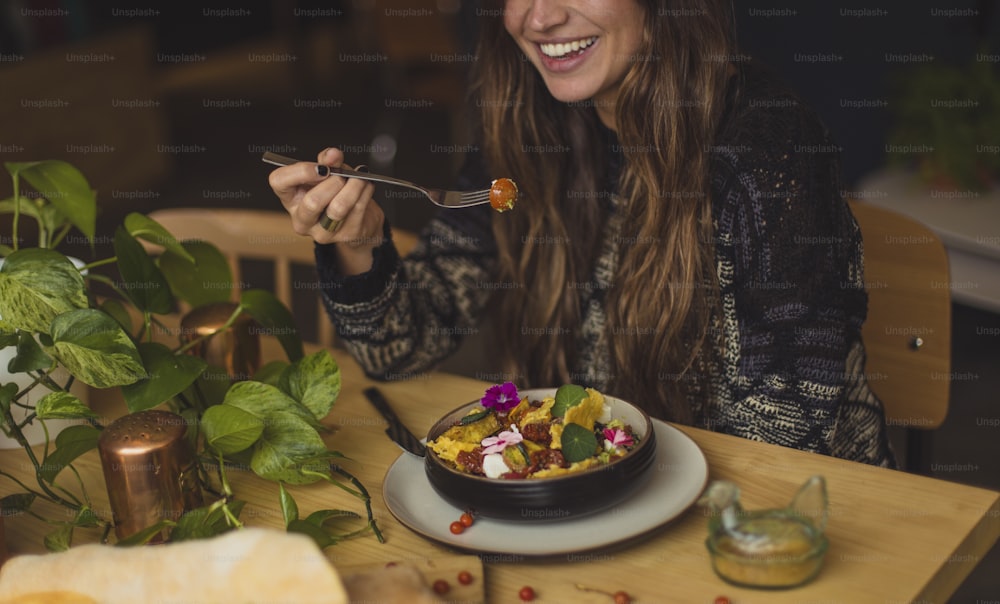 Eine Frau isst einen Teller mit Essen