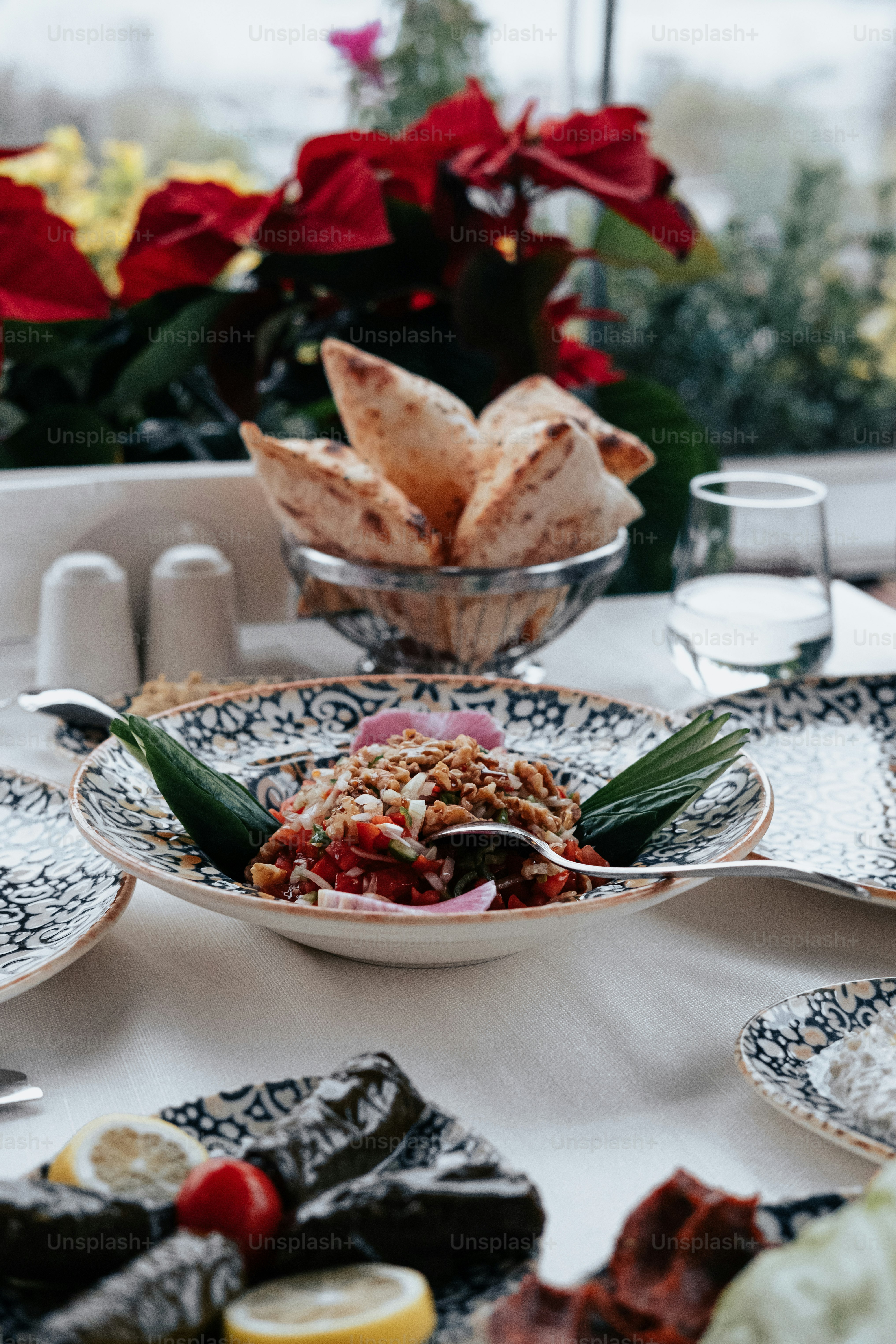 a table with plates of food and a bowl of fruit