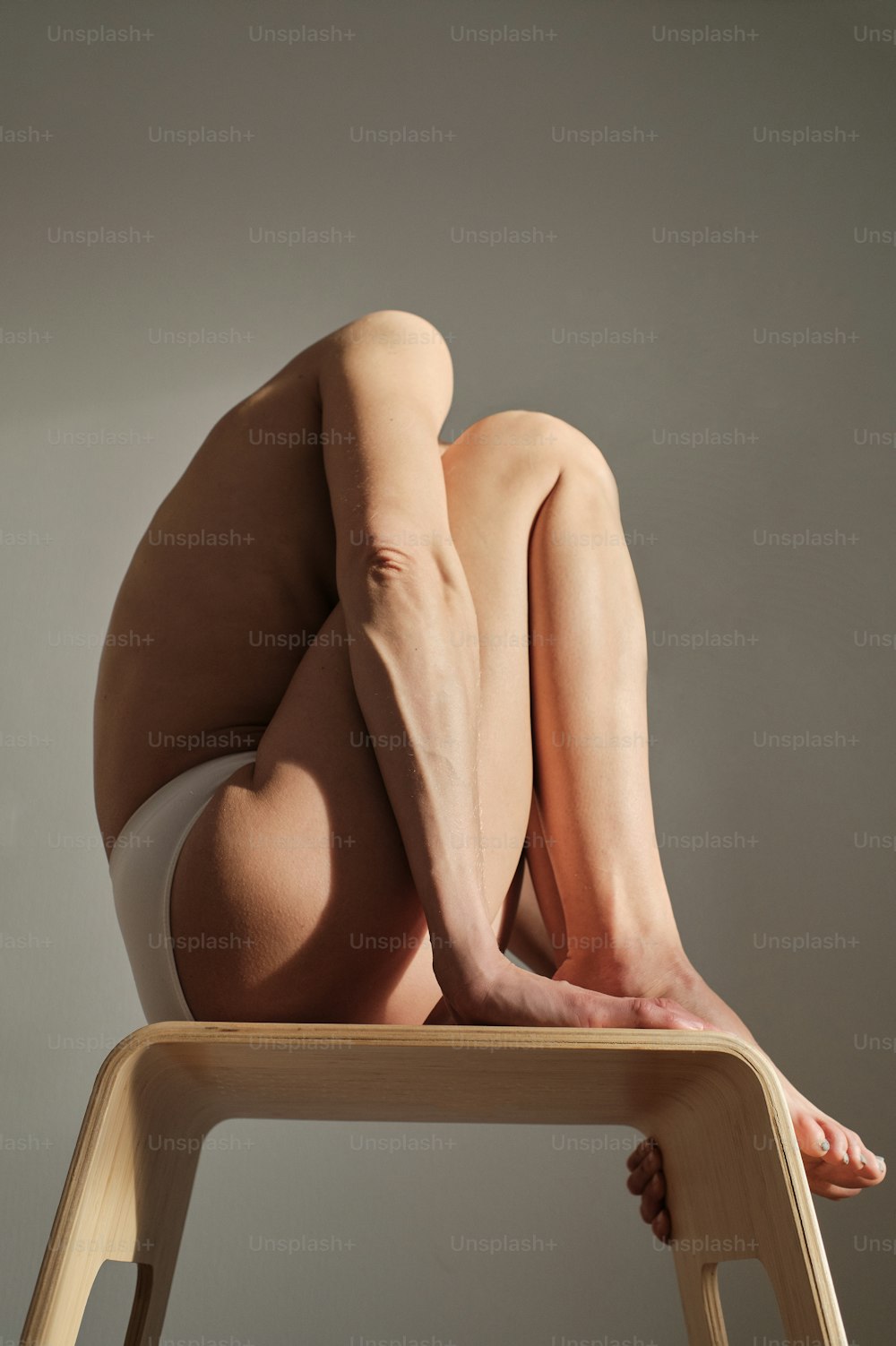 Una donna nuda è seduta su una sedia