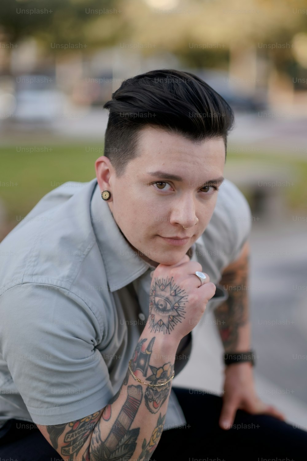 um homem com tatuagens posando para a câmera
