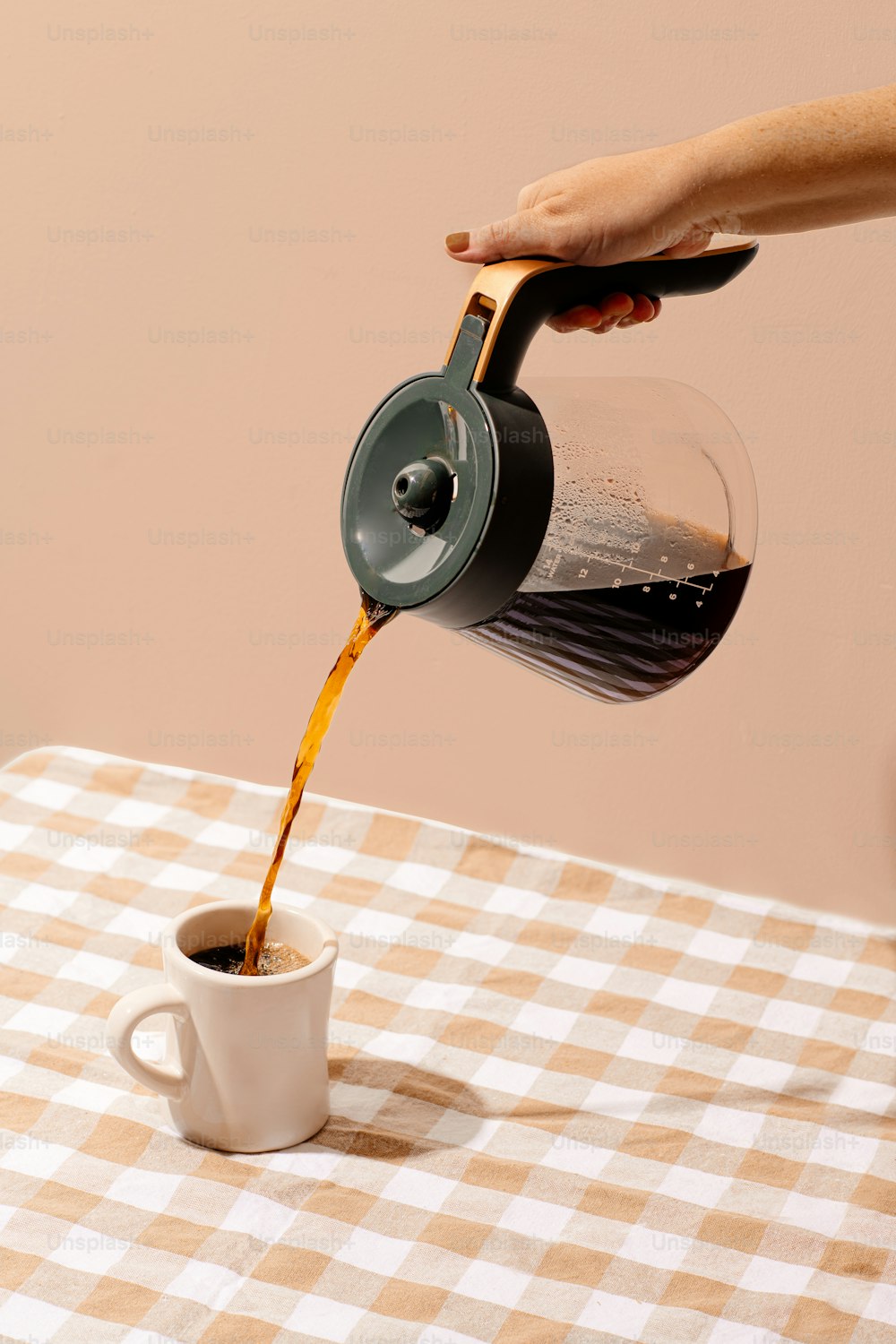 a hand pouring a liquid into a cup