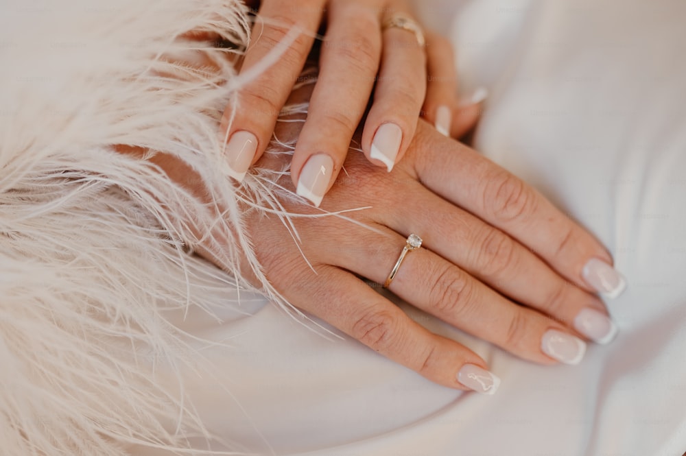 a close up of a person's hands with a ring