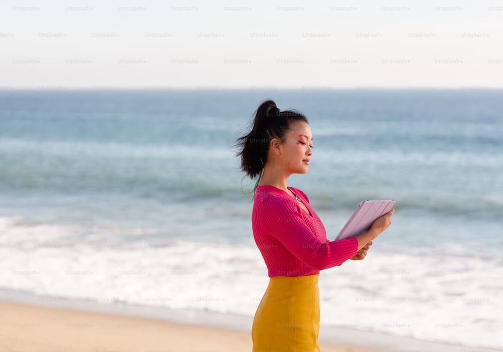 a person holding a book on a beach