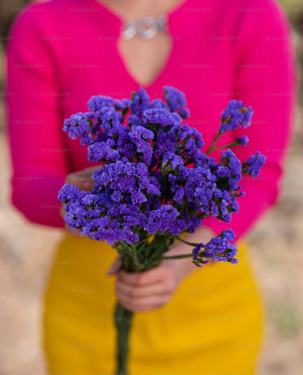 a person holding a bouquet of purple flowers