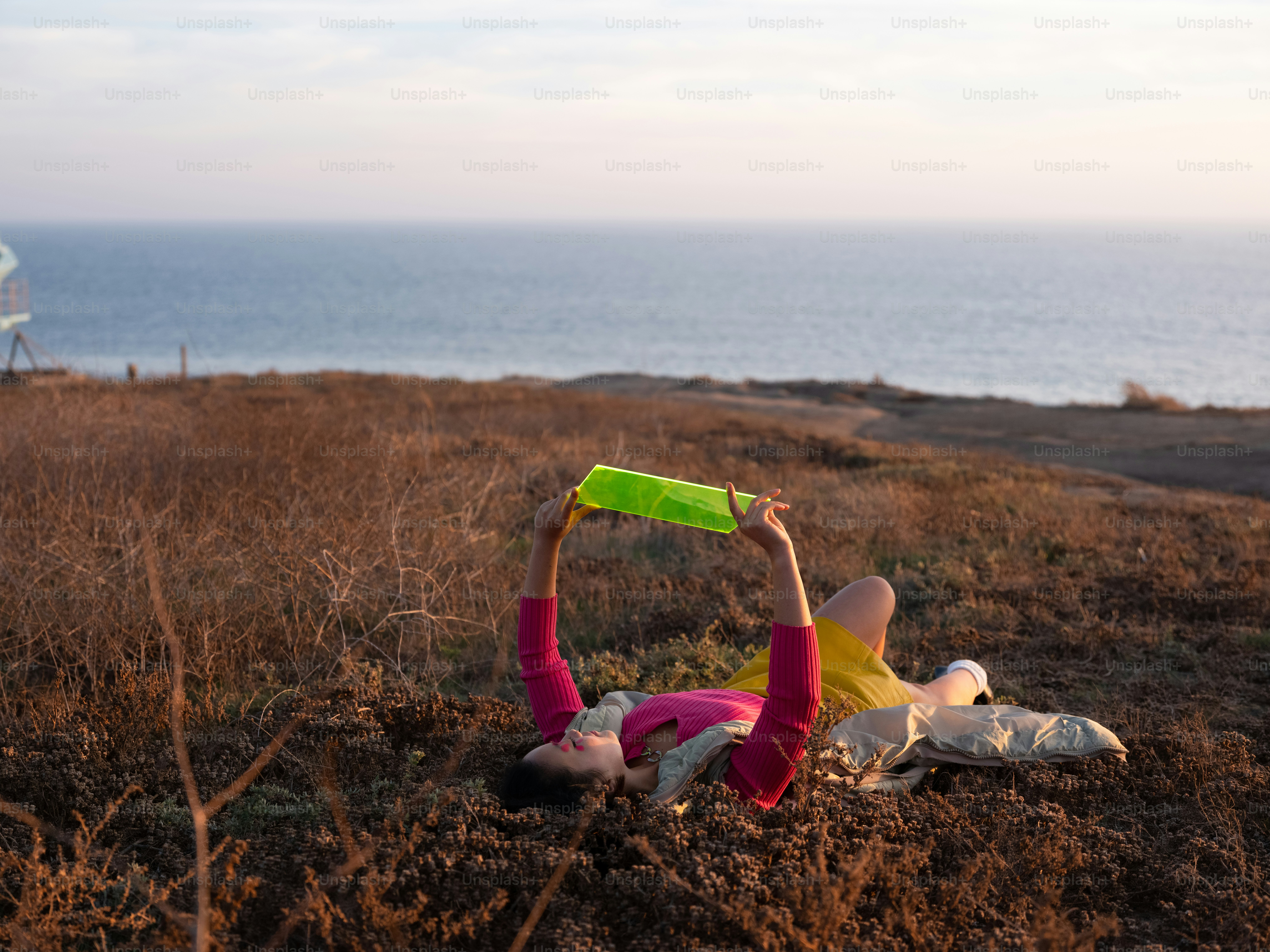 une personne allongée sur le sol avec un objet vert à la main