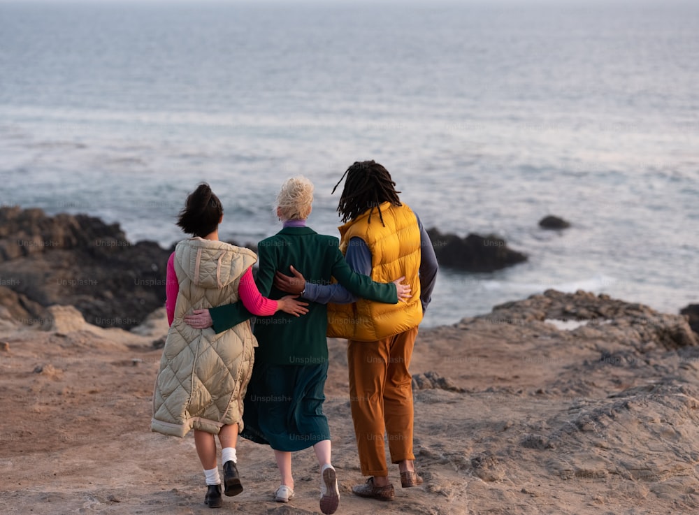 a group of women walking on a rocky beach