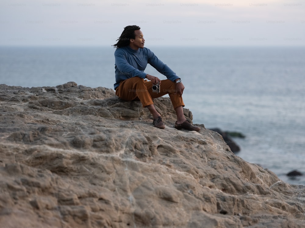 um homem sentado em uma rocha