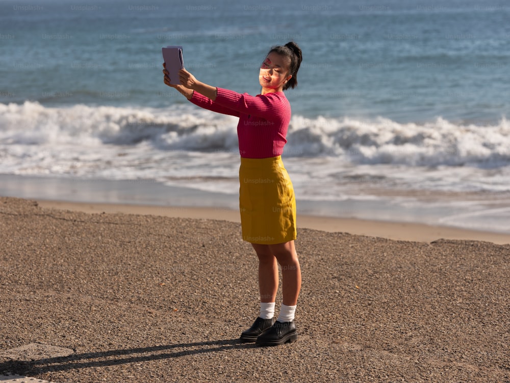 Ein Junge hält ein Telefon am Strand
