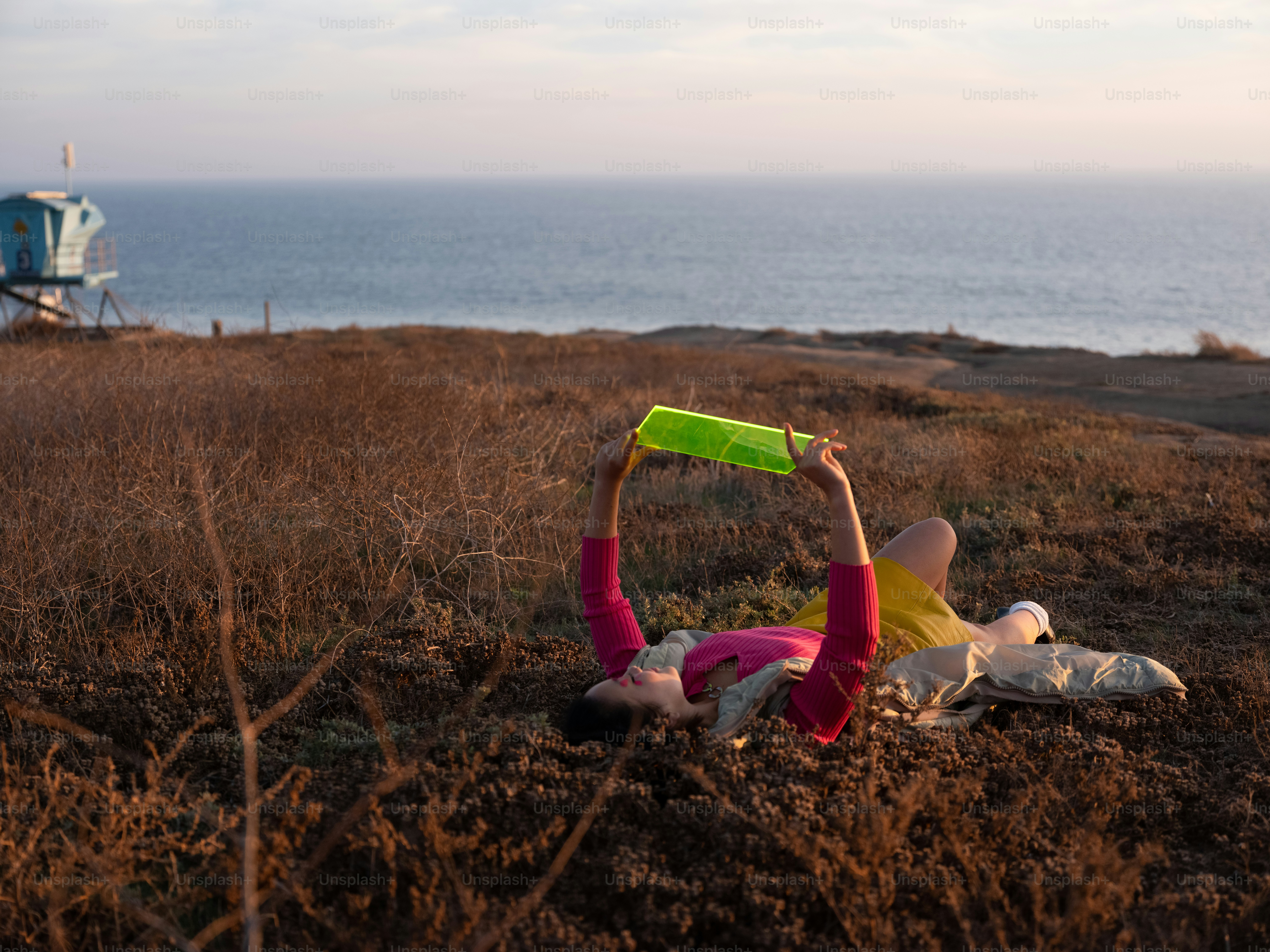 A person lying on the ground with a green object in the hand photo ...