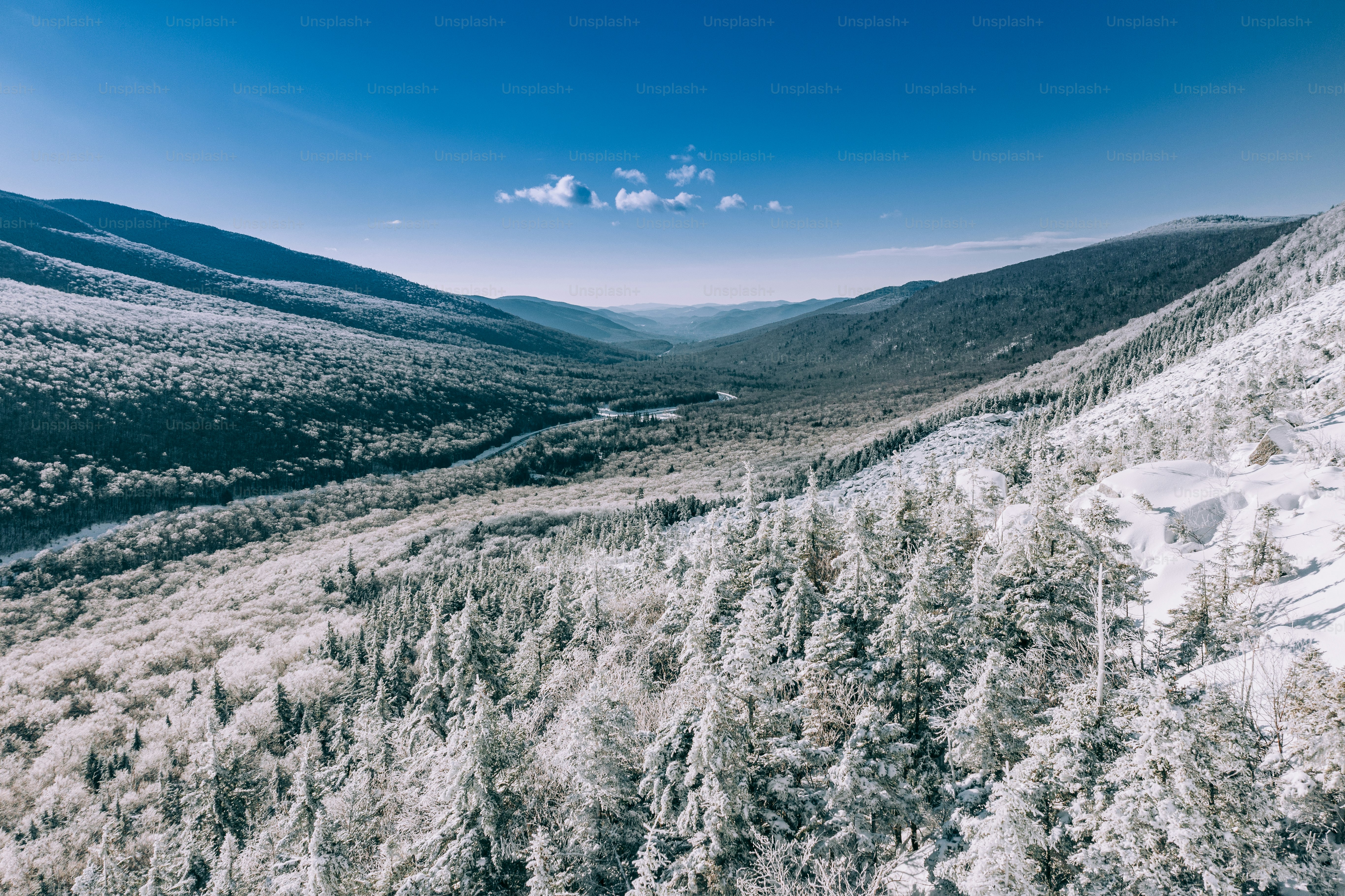 an aerial view of a snowy mountain valley