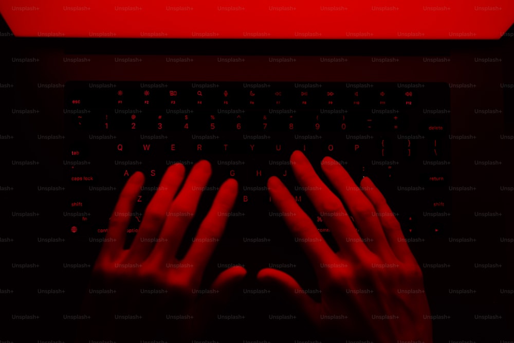 Una persona escribiendo en un teclado con las manos