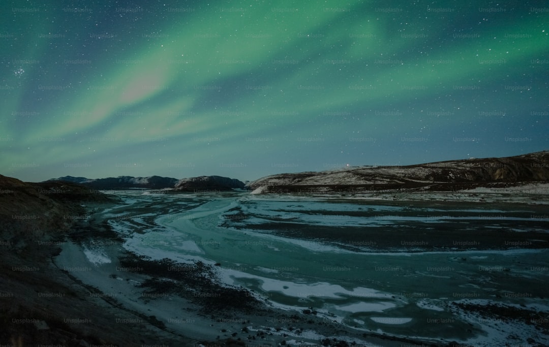a snowy beach with a green sky