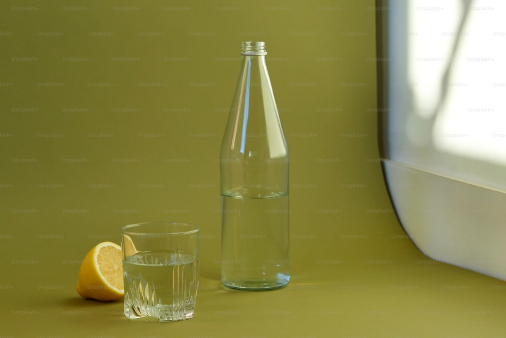 a glass bottle and a glass of water on a table