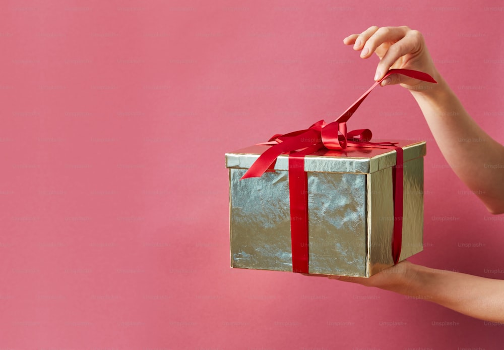 a hand holding a red and clear box with a red handle