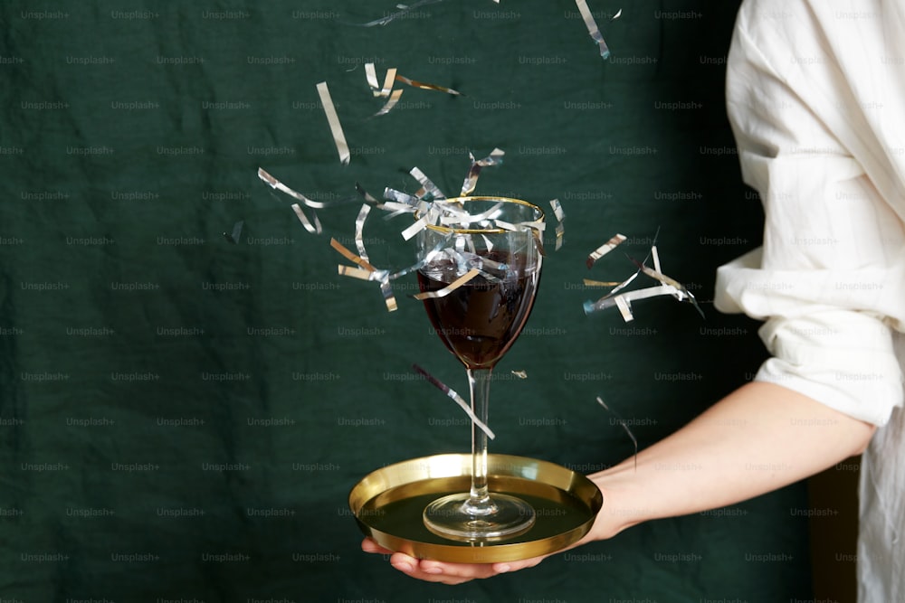 una mano sosteniendo una copa de vino tinto