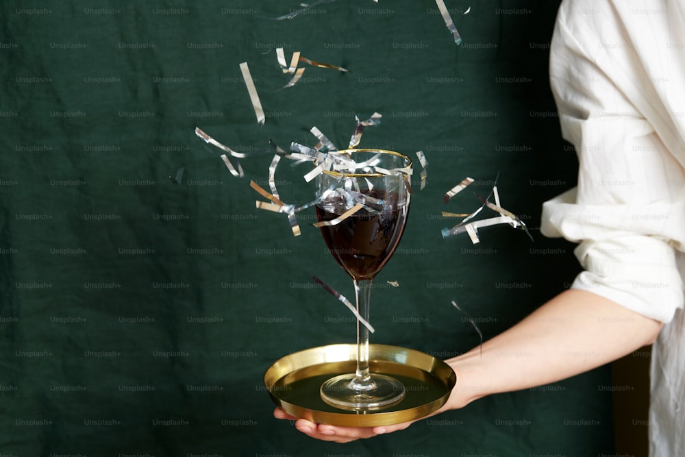 a hand holding a glass of red wine