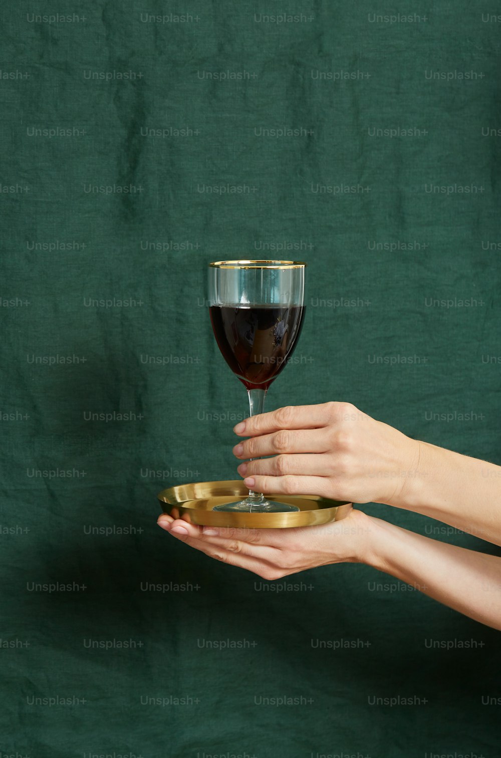 una mano sosteniendo una copa de vino tinto