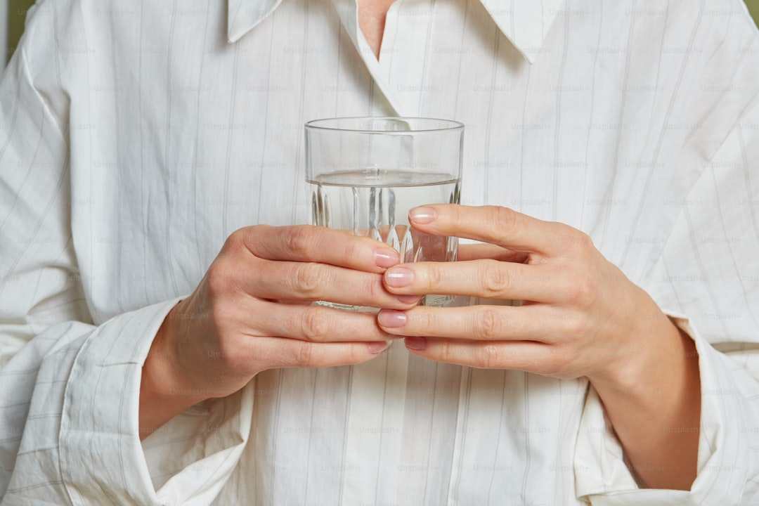 A person holding Alkaline Water glass 