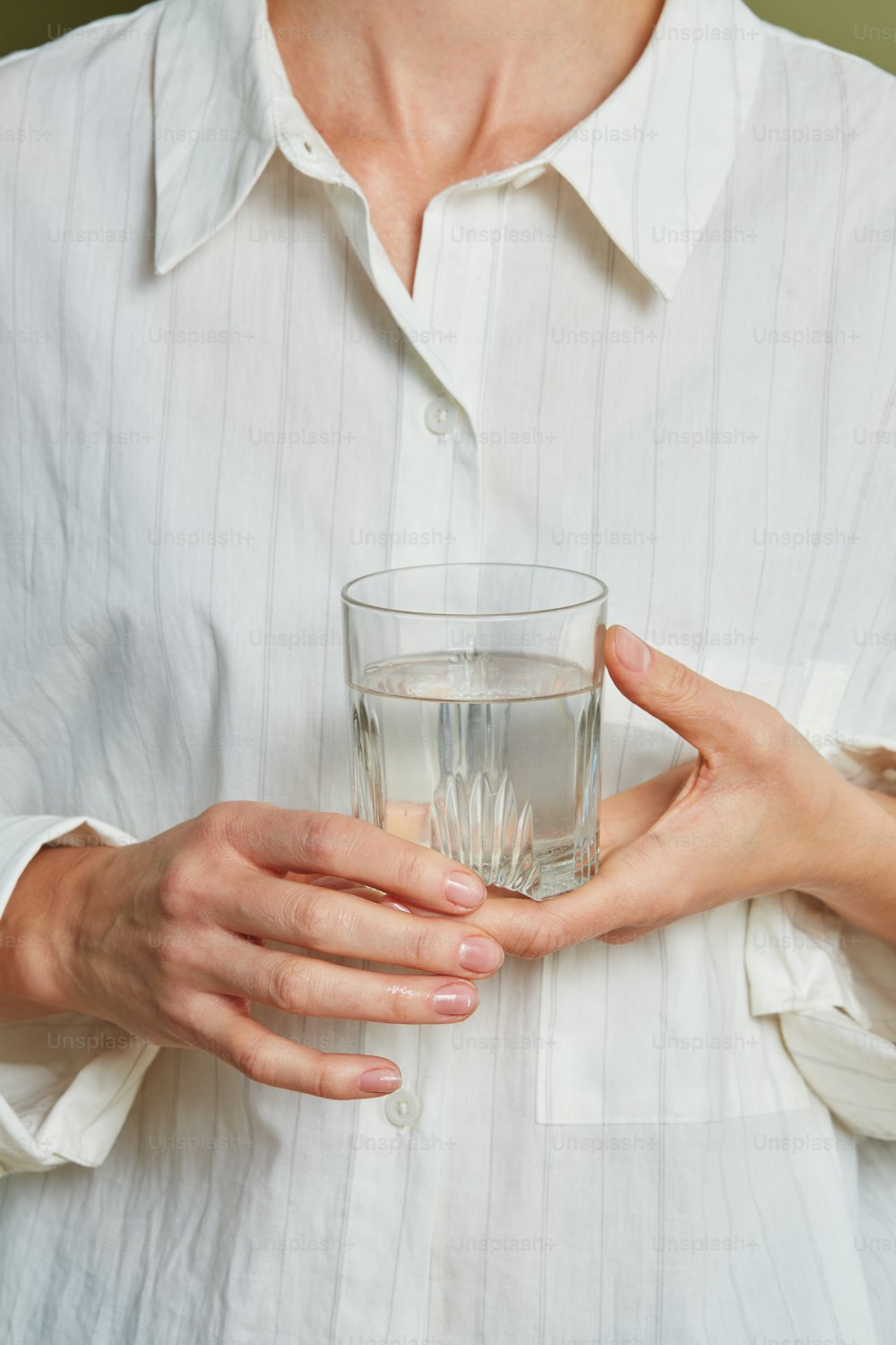 Un hombre sosteniendo un vaso de agua