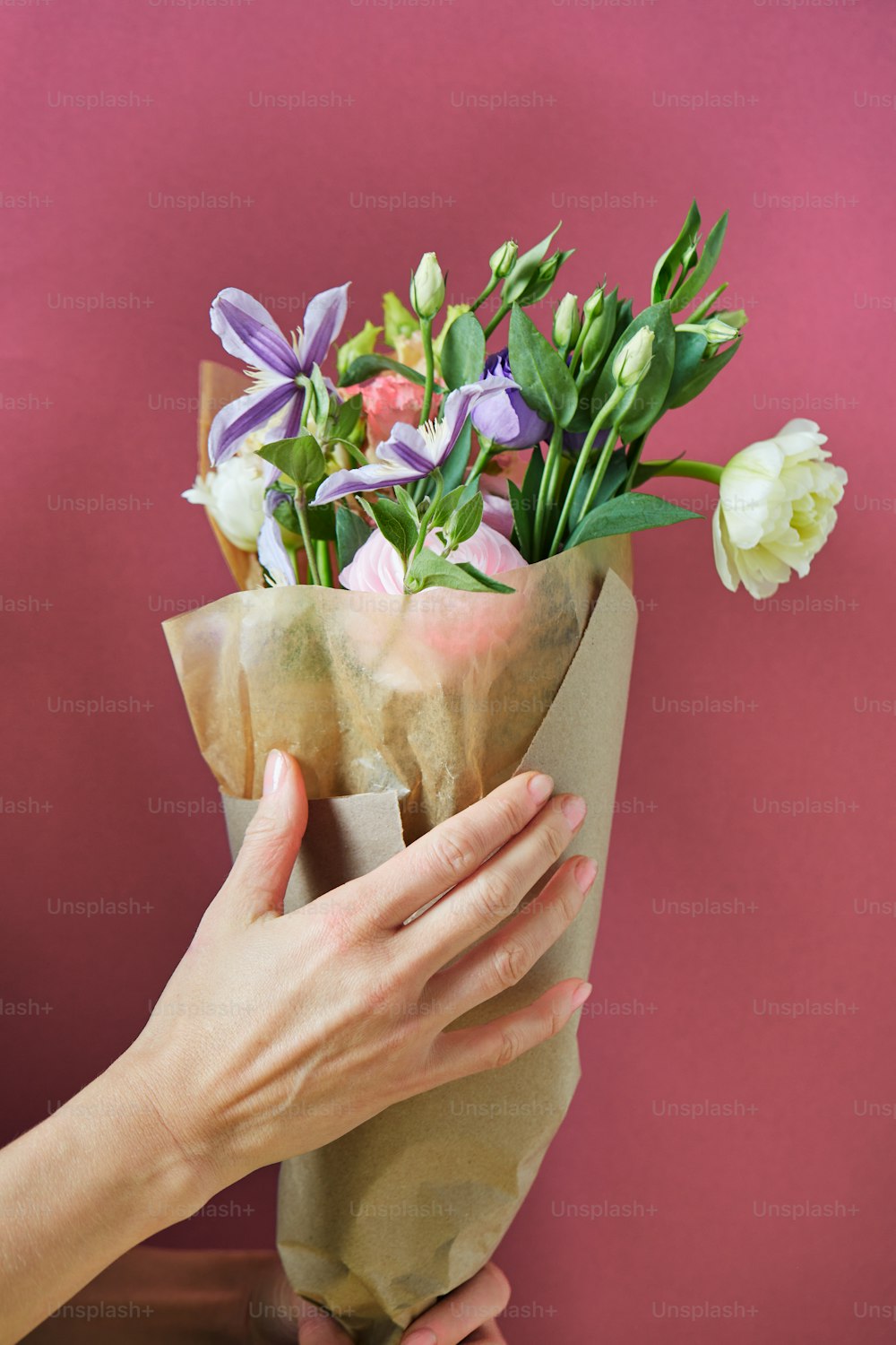 a hand holding a cup of flowers
