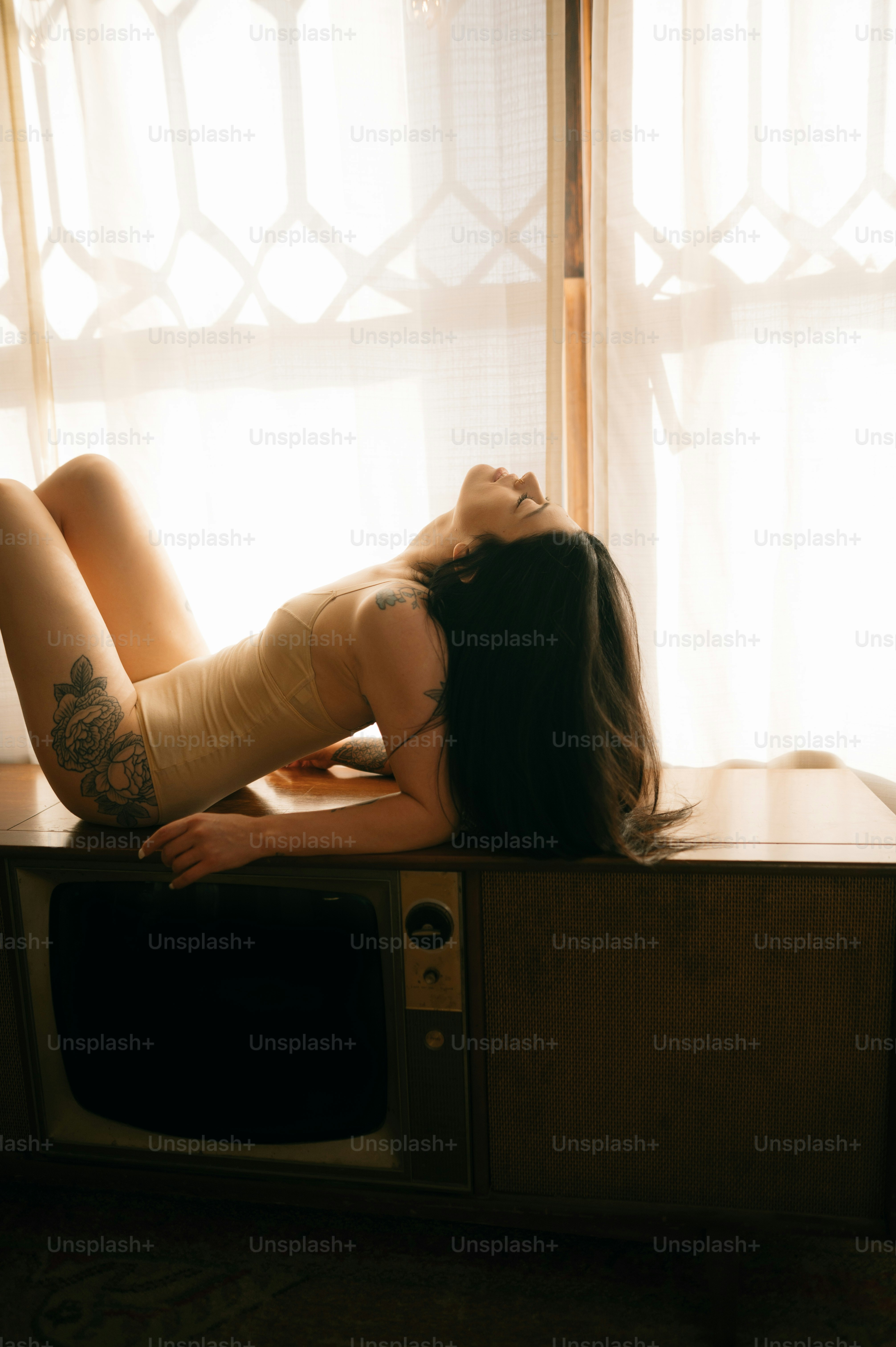 Une femme allongée sur une télévision