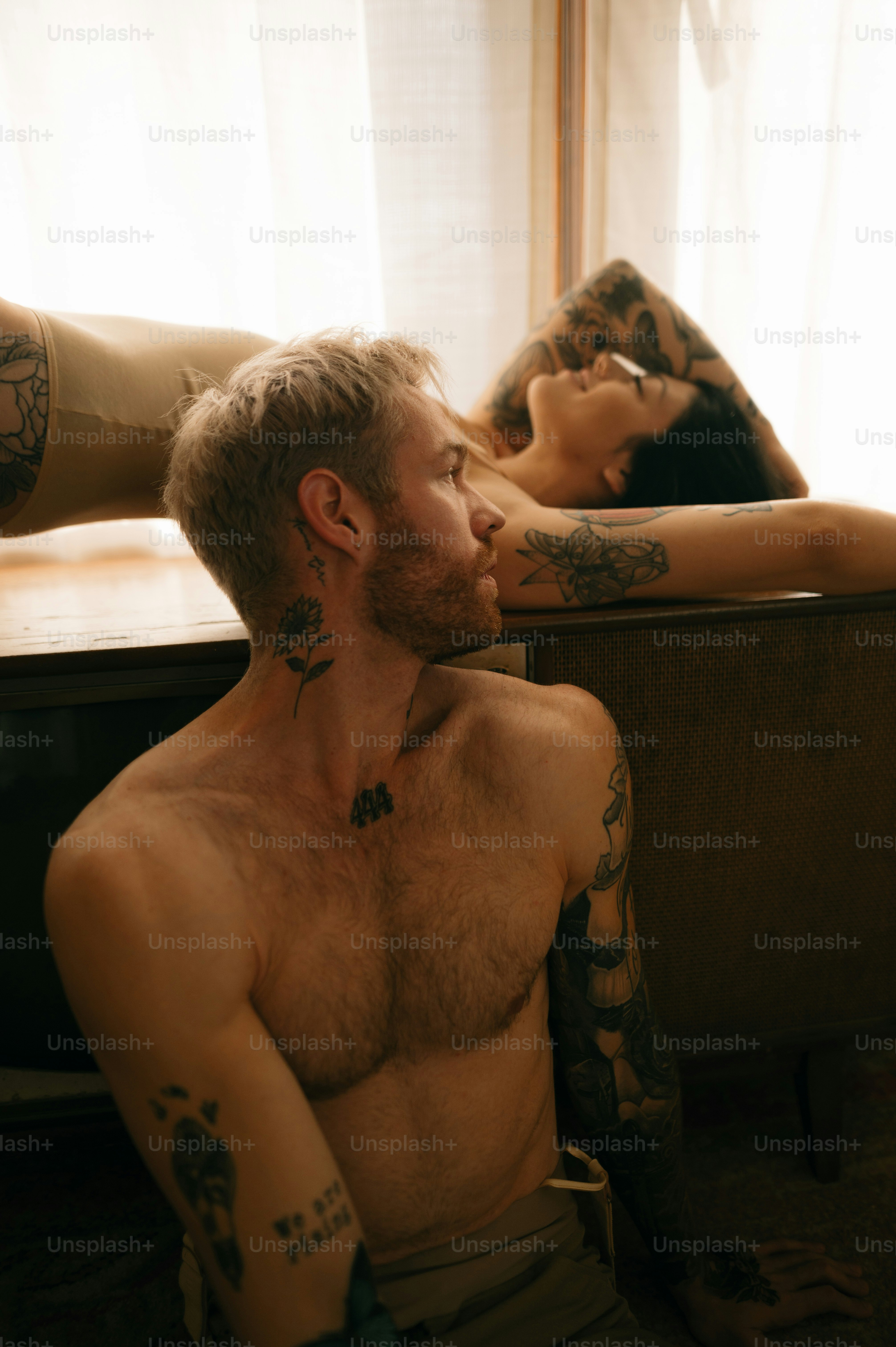 Un homme tatoué embrassant un autre homme