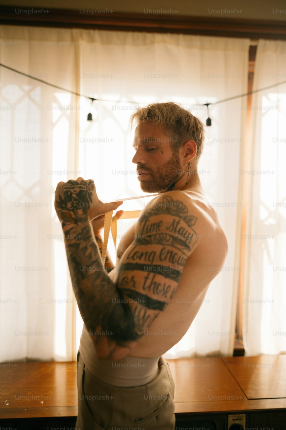 um homem com tatuagens flexionando seus músculos