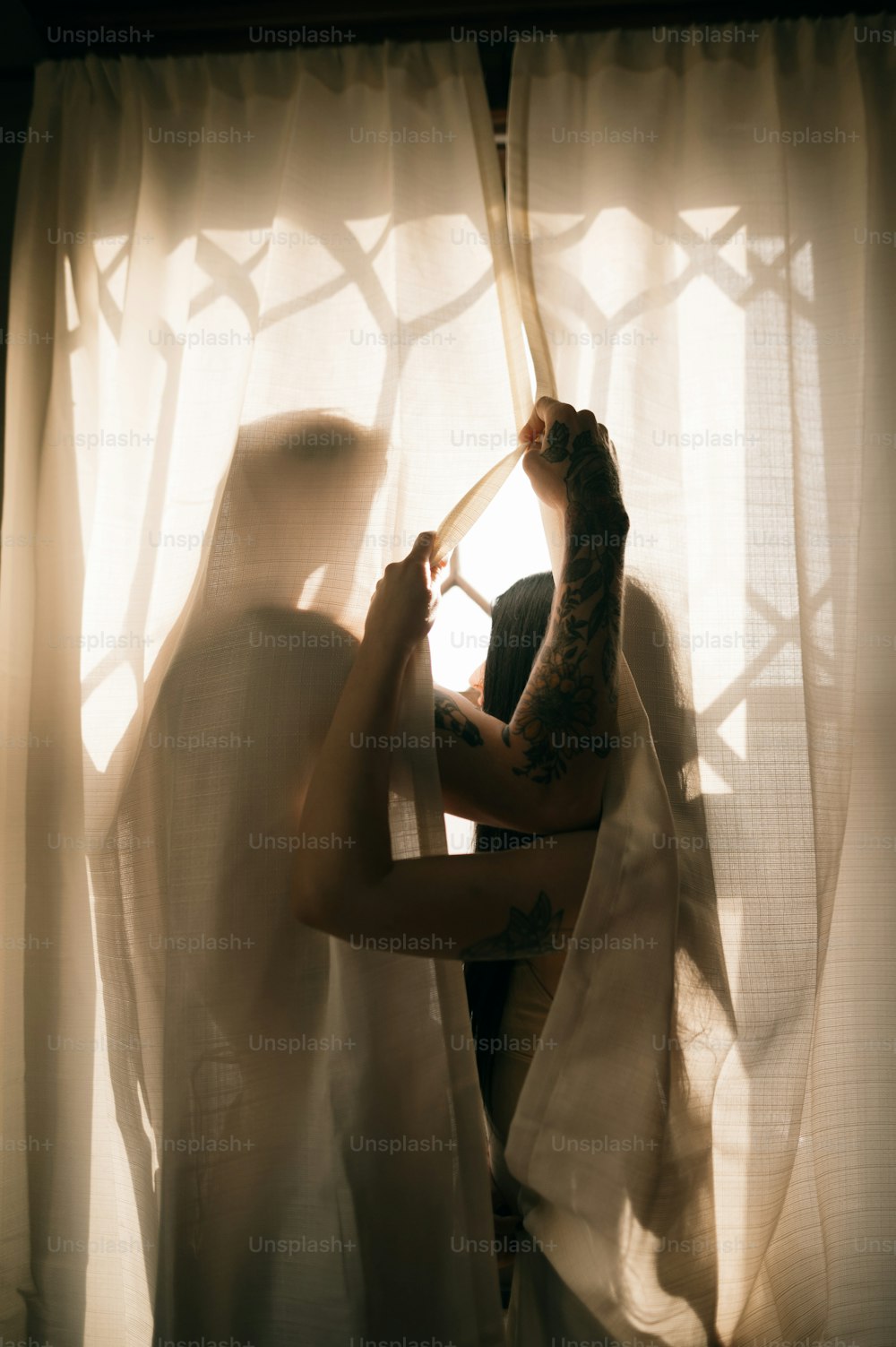 Una persona con un vestido sosteniendo un palo en una ventana