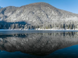 a mountain is reflected in the still water of a lake