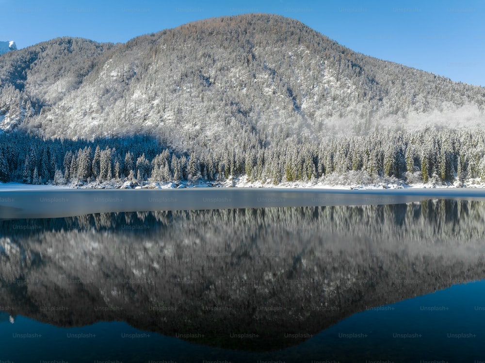 Una montaña se refleja en el agua quieta de un lago