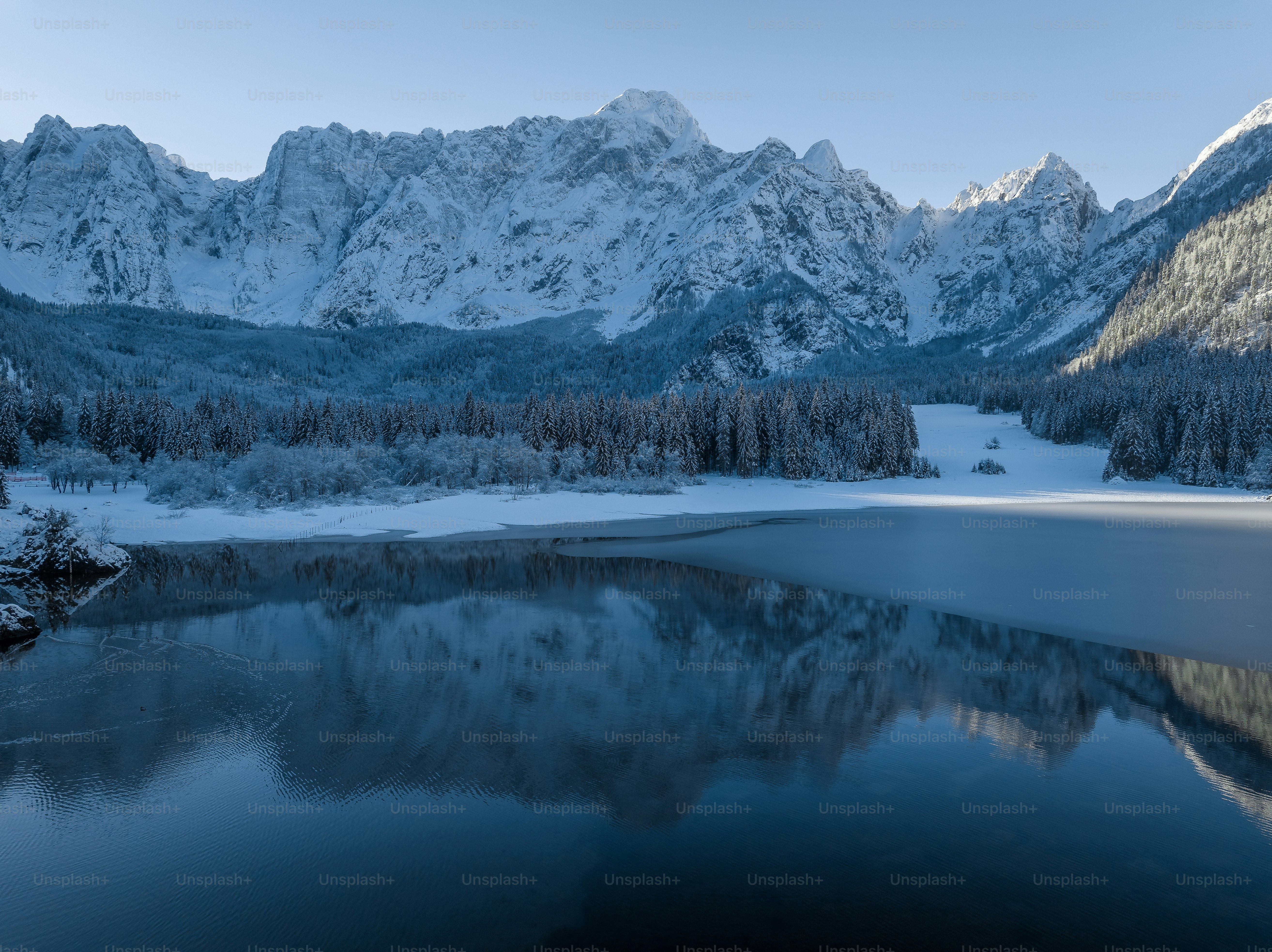 A lake surrounded by snow covered mountains photo – Backgrounds Image ...