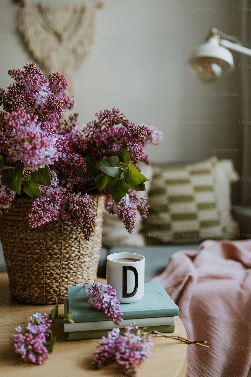 una canasta de flores y una taza de café sobre una mesa