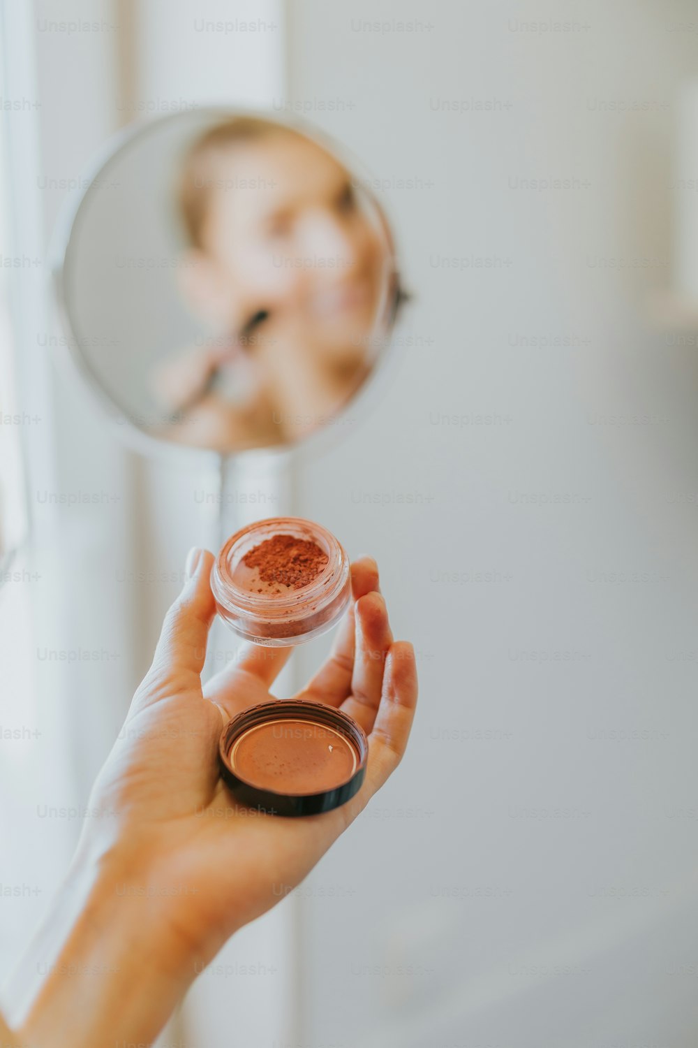 a person holding a small glass jar