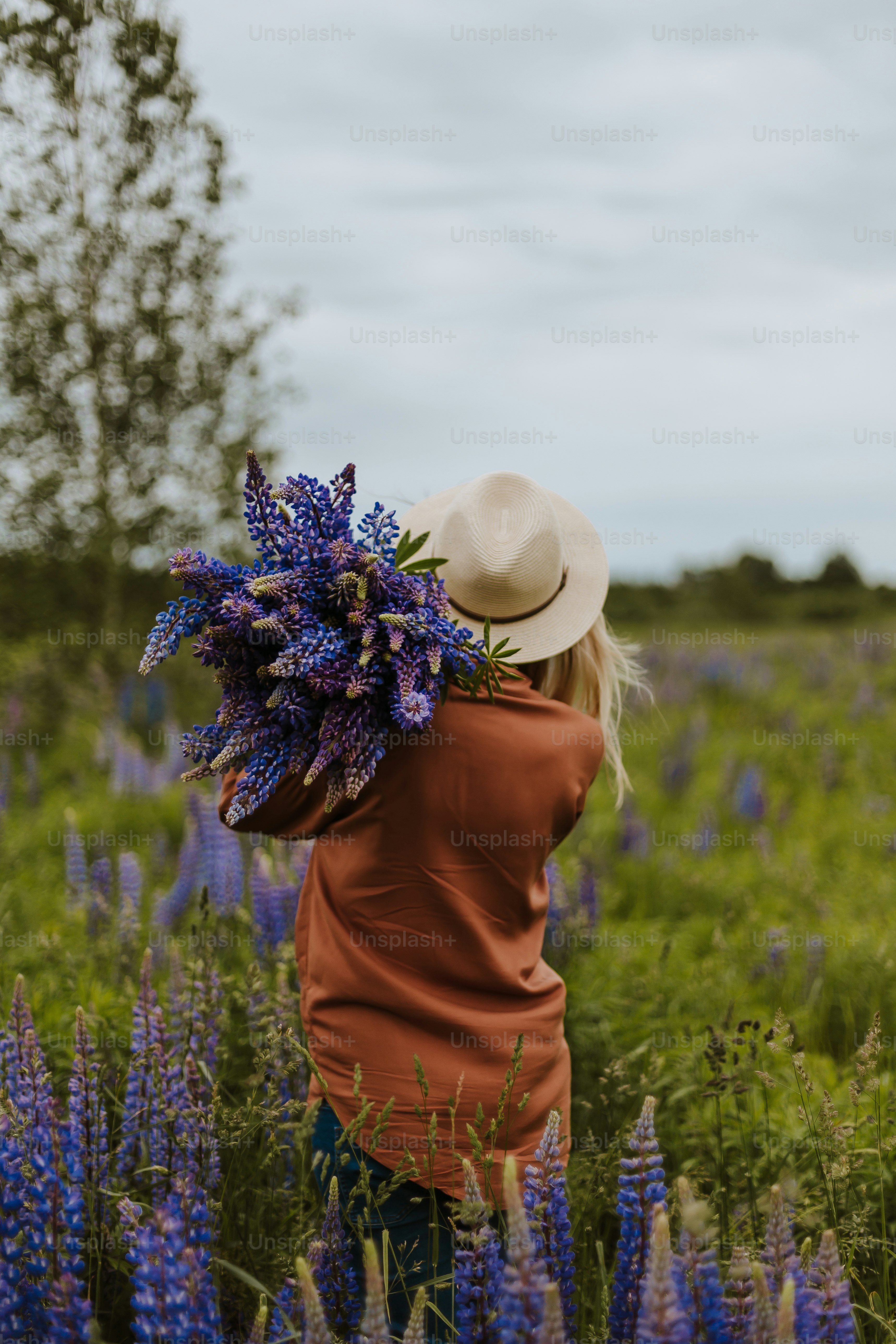 Una persona con sombrero en un campo de flores