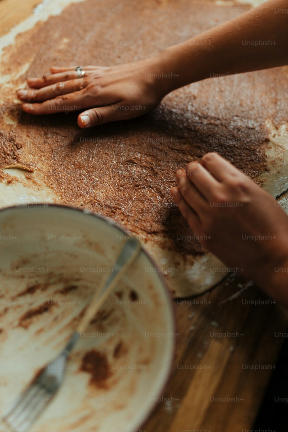 a person with their hands on a pan of food