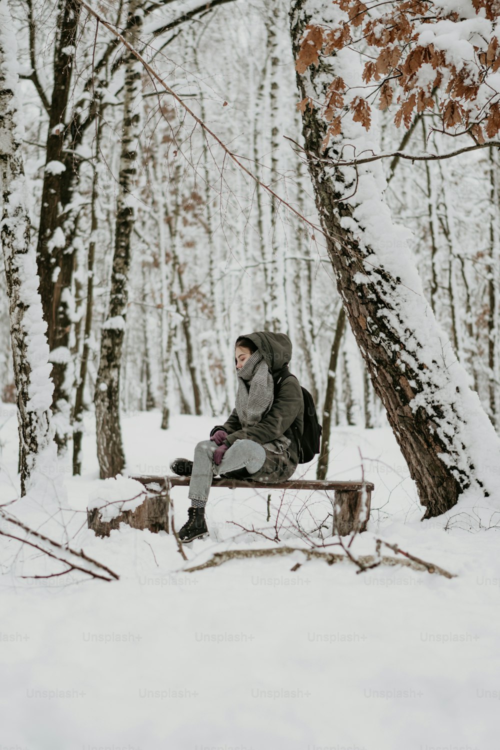 Una persona sentada en un banco en la nieve