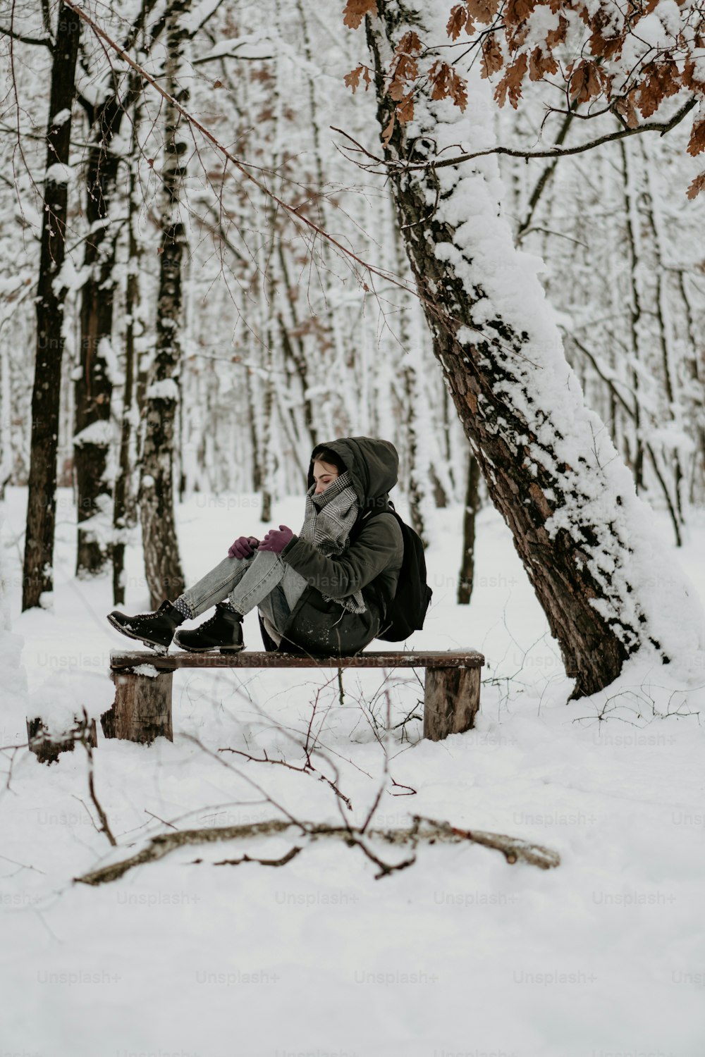 a person sitting on a bench in the snow