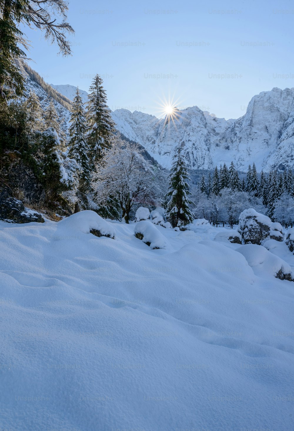 the sun is shining over the snowy mountains