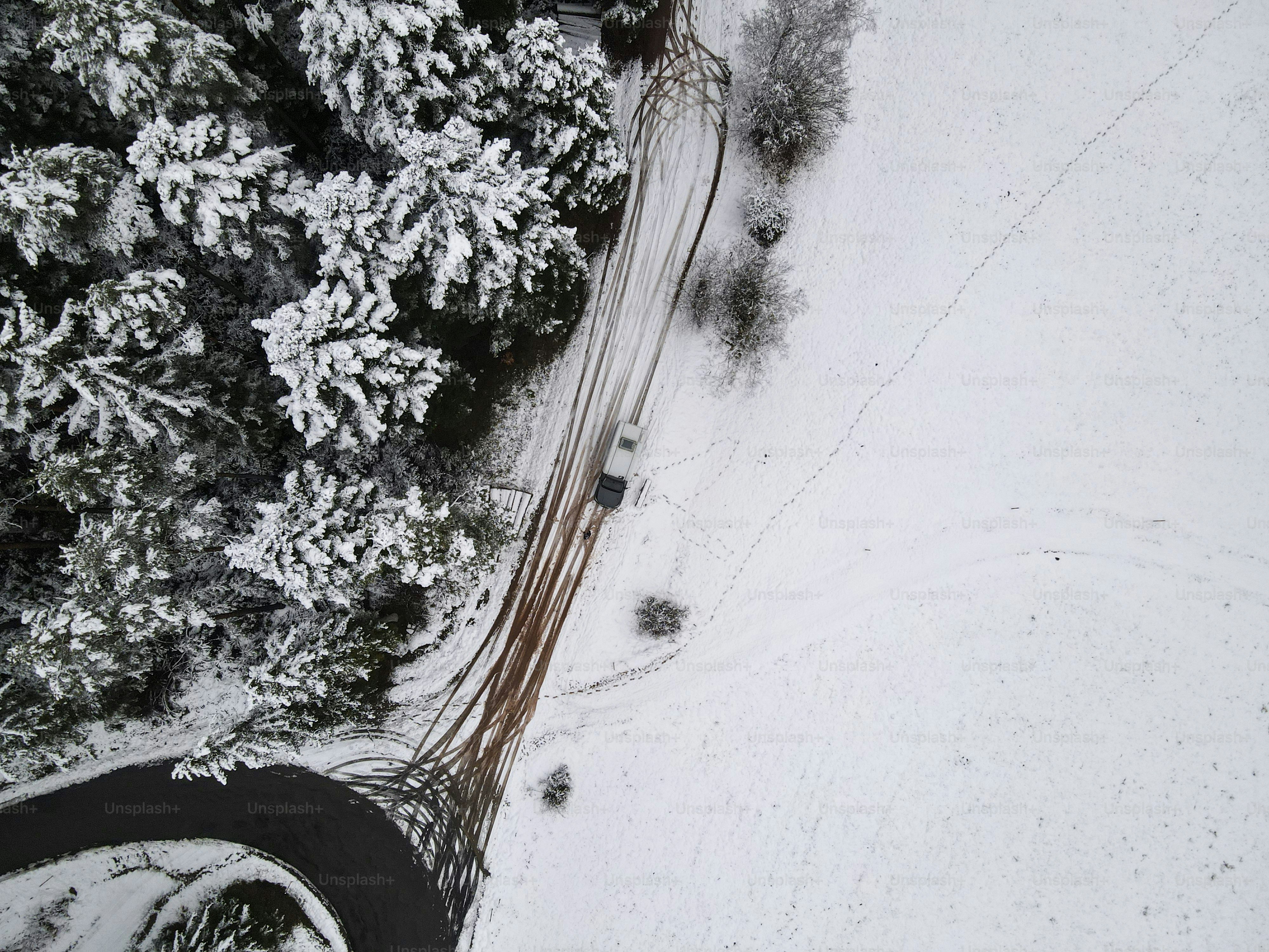 Luftaufnahme eines Autos, das auf einer verschneiten Straße fährt