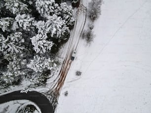 an aerial view of a car driving on a snowy road