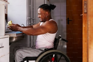 a man in a wheel chair washing dishes