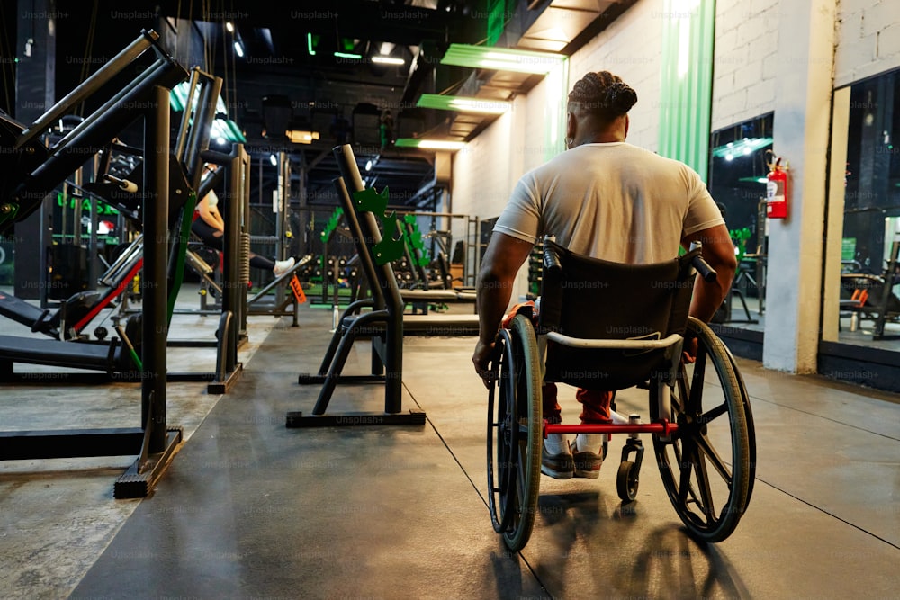 Ein Mann im Rollstuhl in einem Fitnessstudio