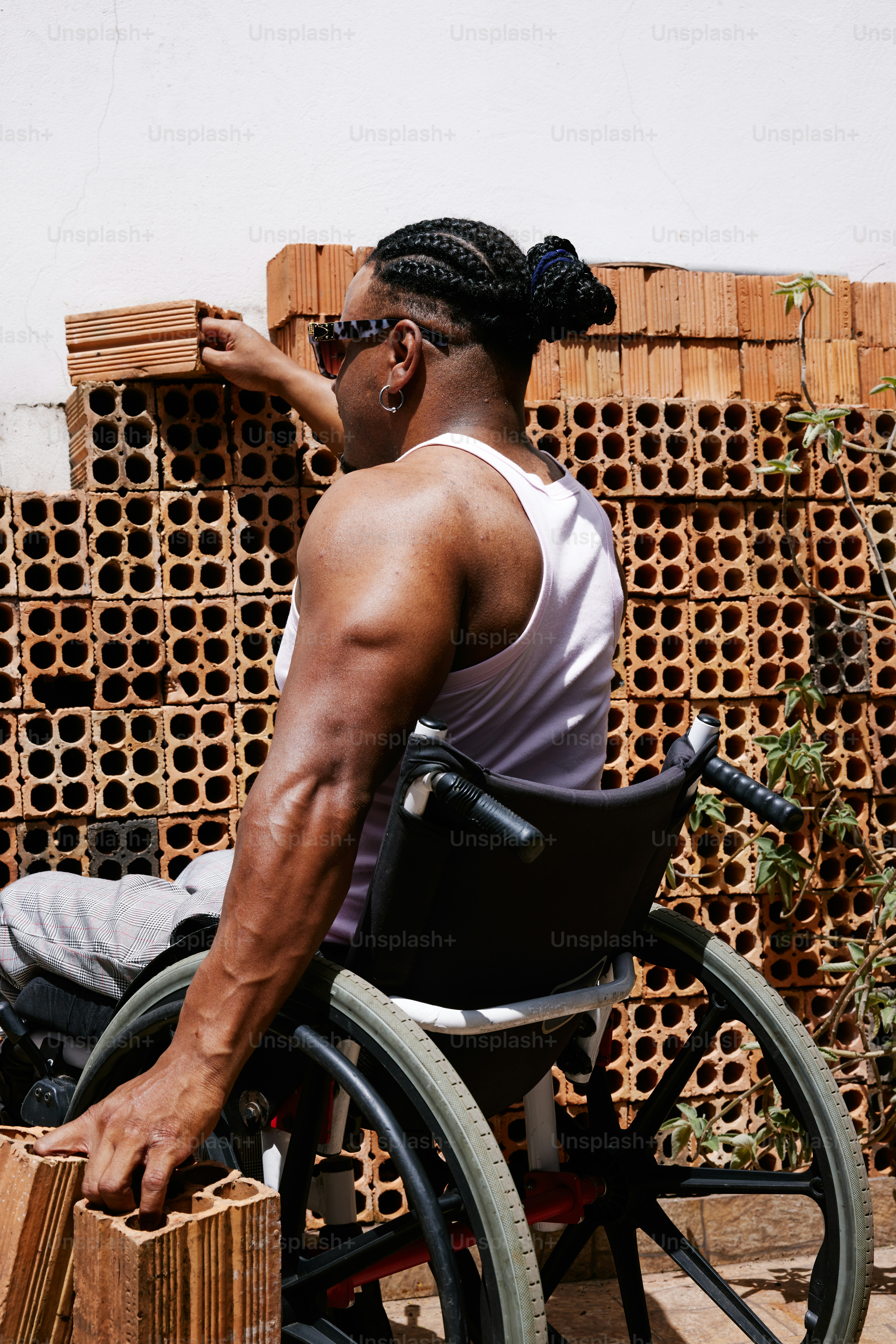 a man in a wheel chair with a bunch of bricks