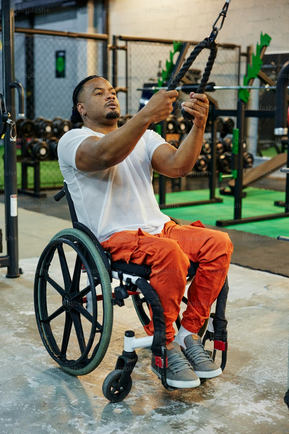 Un hombre en una silla de ruedas sosteniendo una barra
