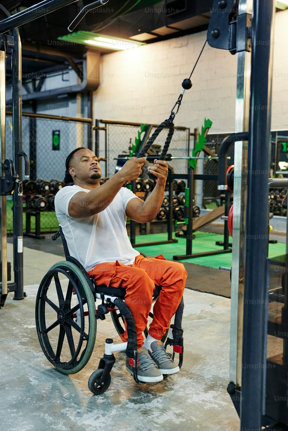 Un hombre en una silla de ruedas sosteniéndose de una barra